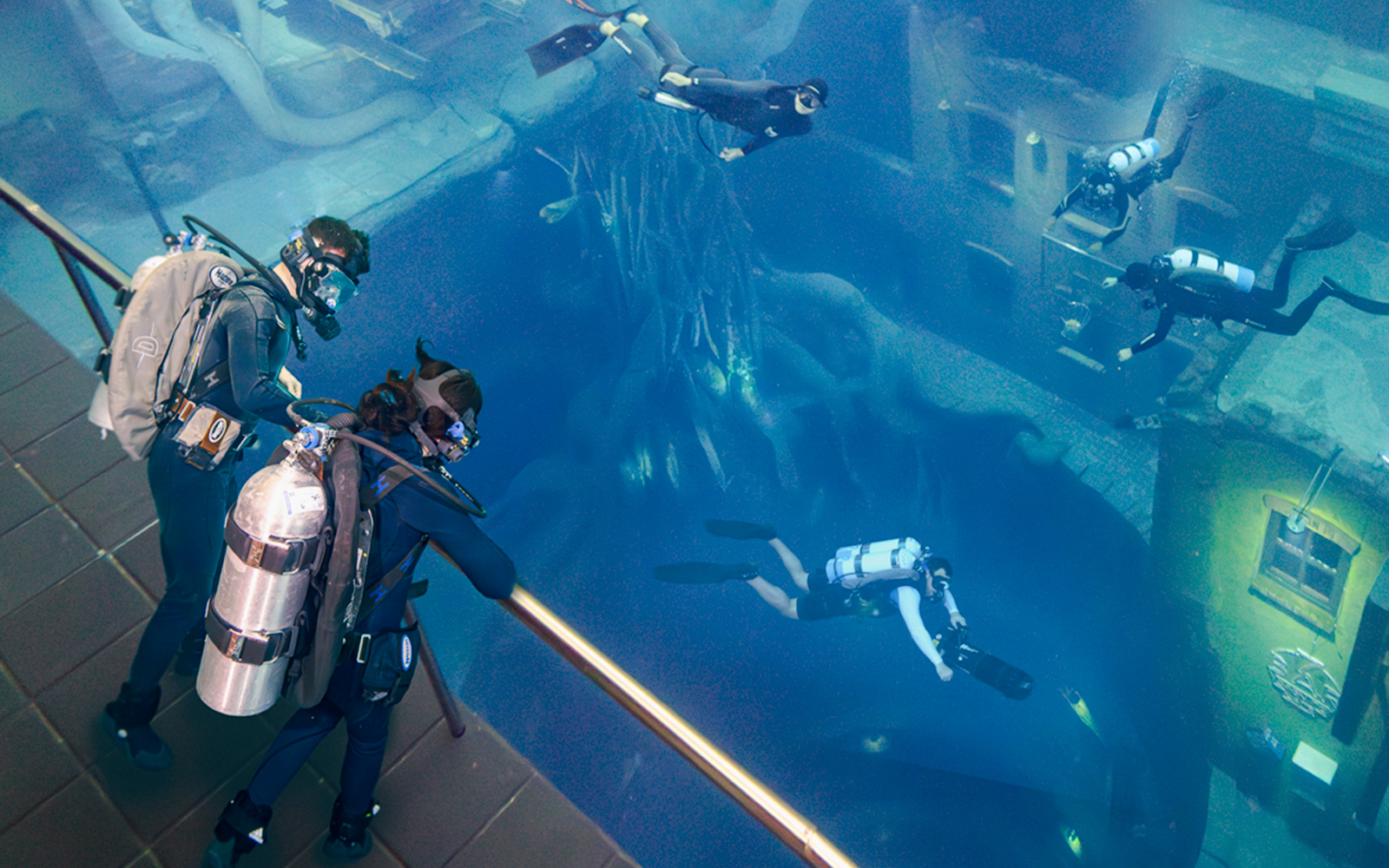 Divers exploring underwater ruins during the Sunken City Walk tour.