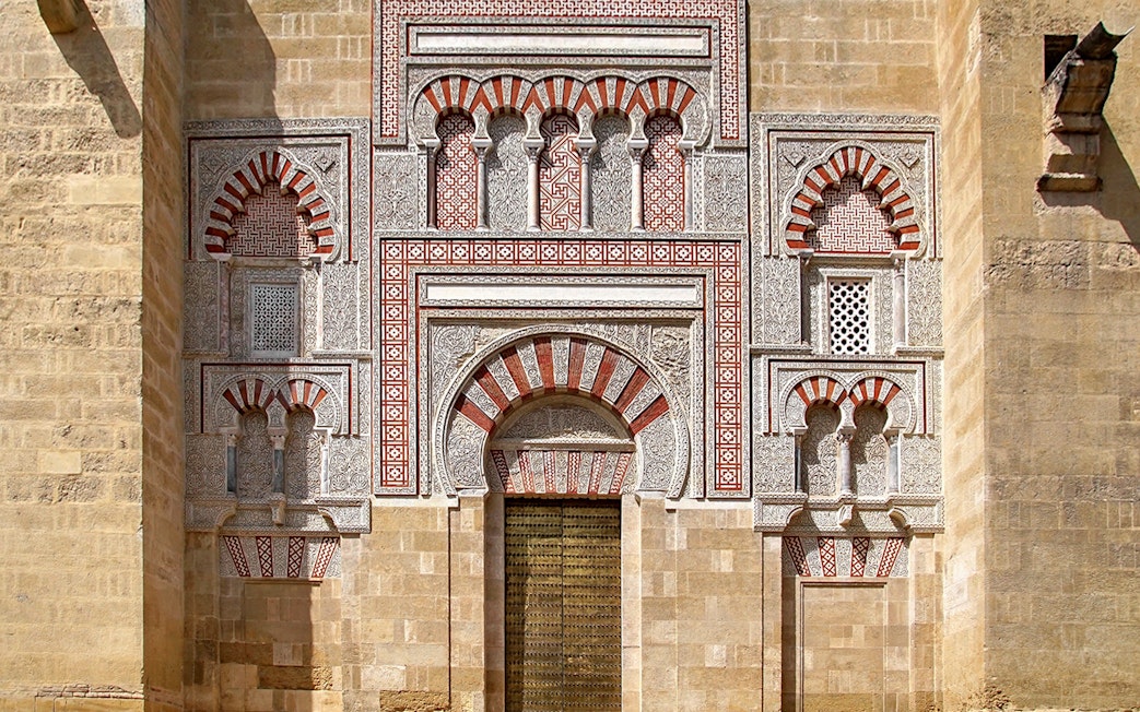 Entrance of the Cordoba Mosque-Cathedral with intricate arches and geometric patterns.