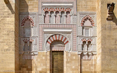 Entrance of the Cordoba Mosque-Cathedral with intricate arches and geometric patterns.