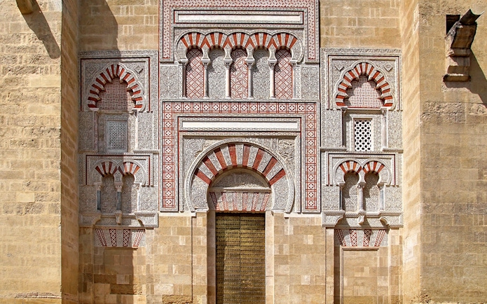 Entrance of the Cordoba Mosque-Cathedral with intricate arches and geometric patterns.