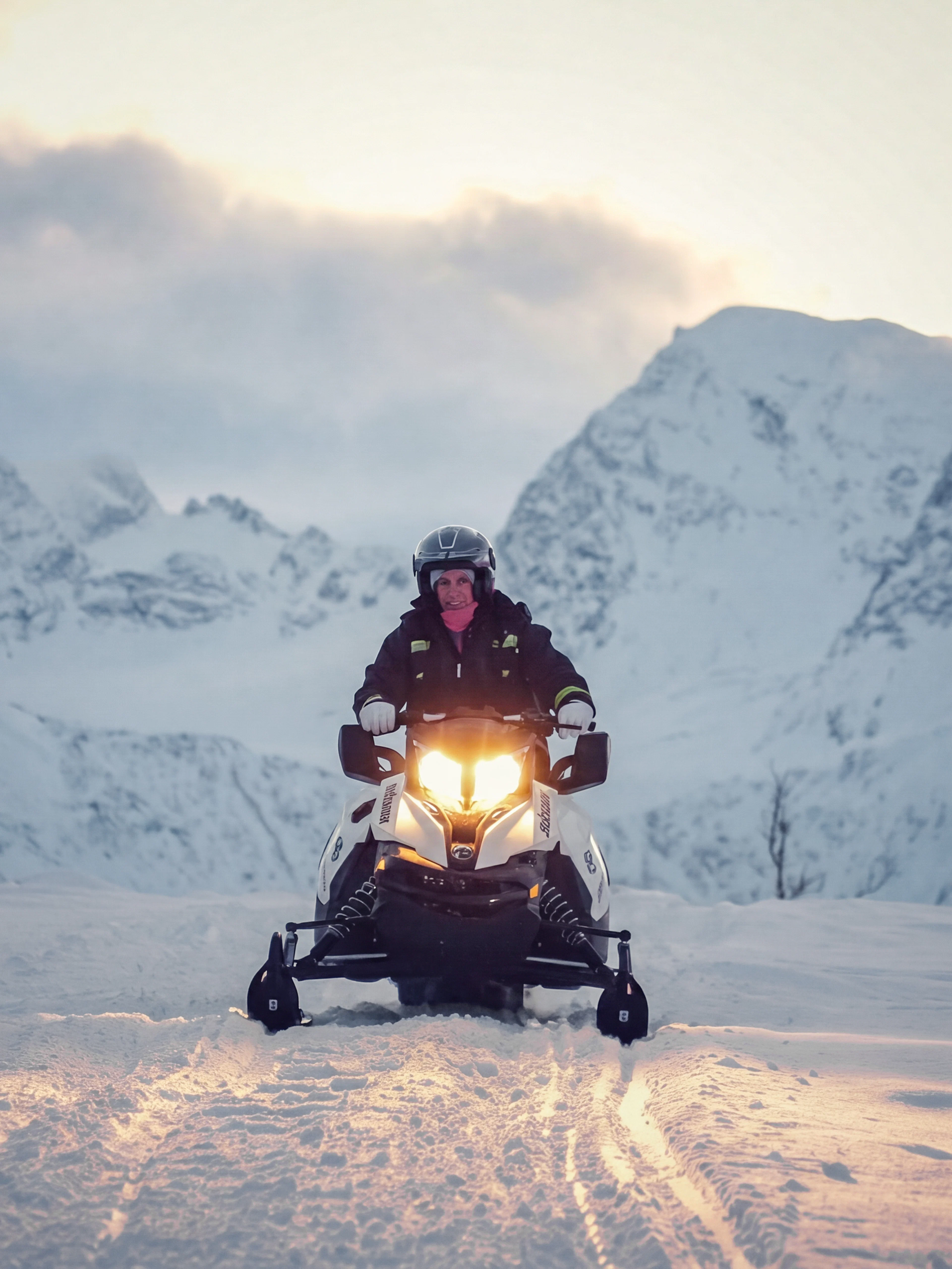 Guest riding a snowmobile in the snowy Lyngen Alps, Tromsø.