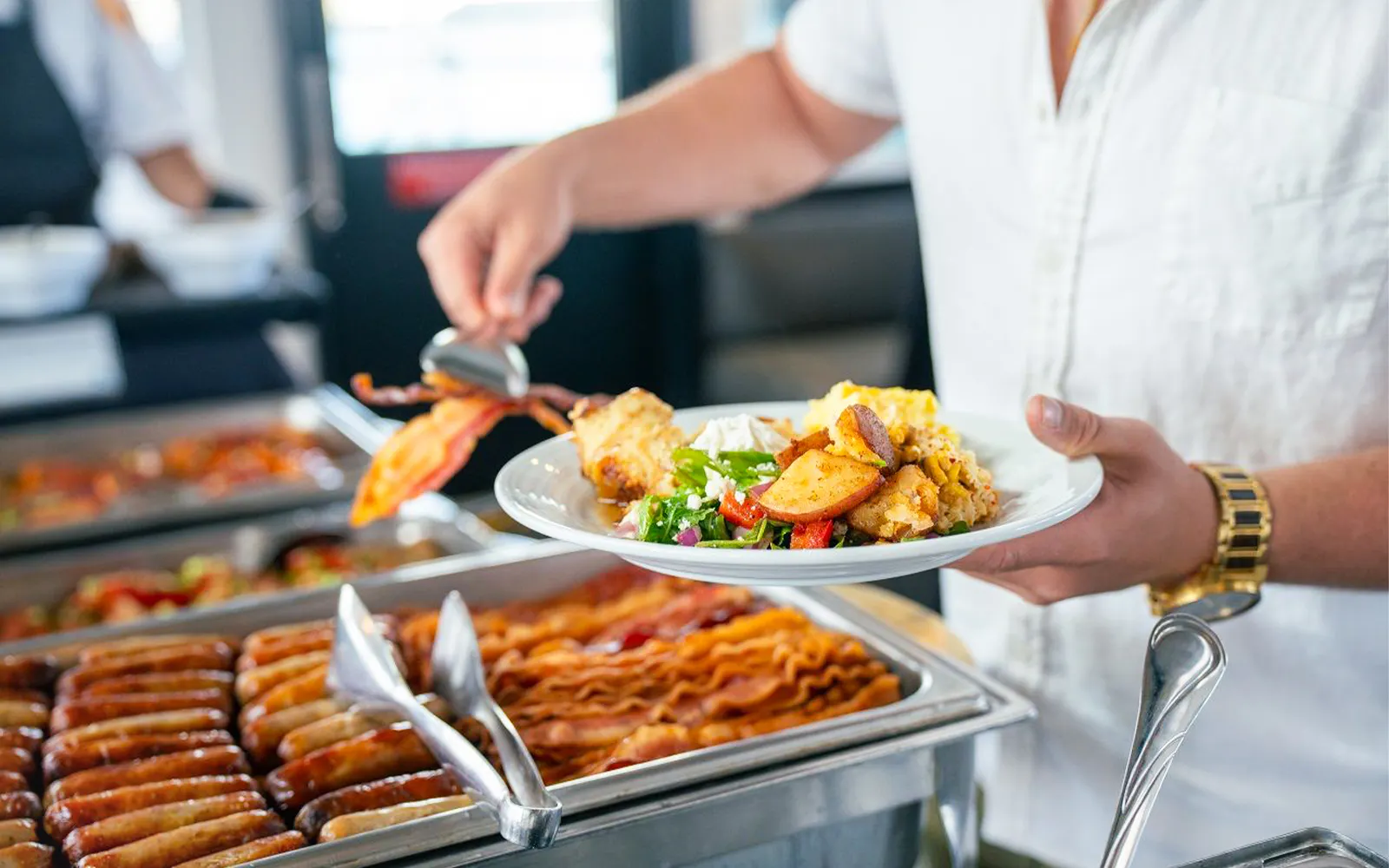 Guest serving food from buffet on San Diego brunch cruise.