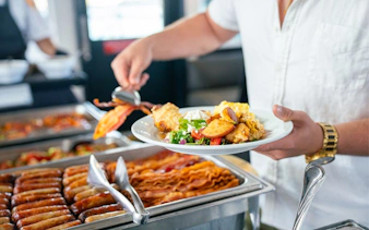 Guest serving food from buffet on San Diego brunch cruise.
