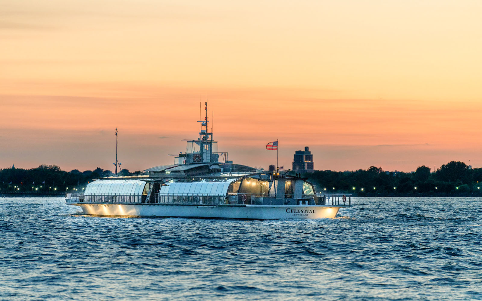 Cruise boat on New York Harbor at sunset during Bateaux New York Premier Lunch Cruise.