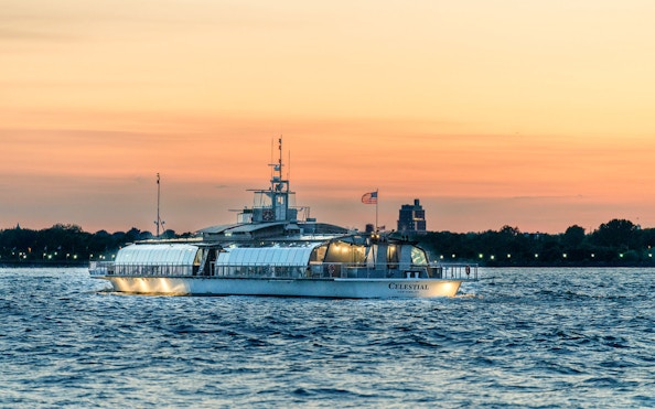 Cruise boat on New York Harbor at sunset during Bateaux New York Premier Lunch Cruise.