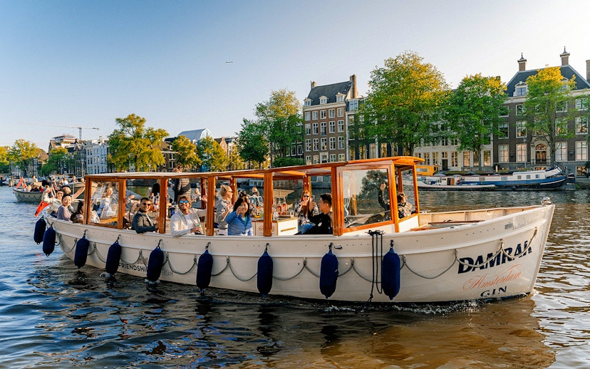 Luxury canal cruise boat with passengers on Amsterdam canal.