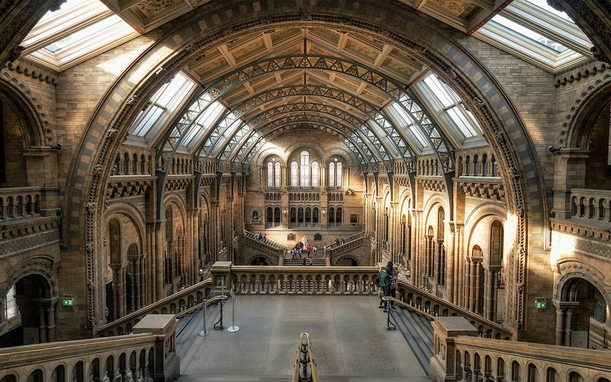 Interior view of the British Museum's grand hall with arched ceilings and visitors exploring.