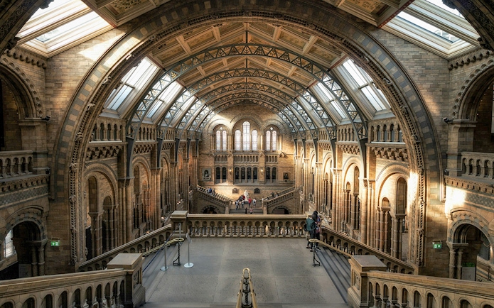 Interior view of the British Museum's grand hall with arched ceilings and visitors exploring.