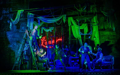 Stage performance of Moulin Rouge! The Musical in West End with actors in vibrant costumes.