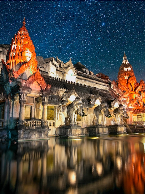 Phuket Fantasea illuminated temple with elephant statues at night, Phuket, Thailand.
