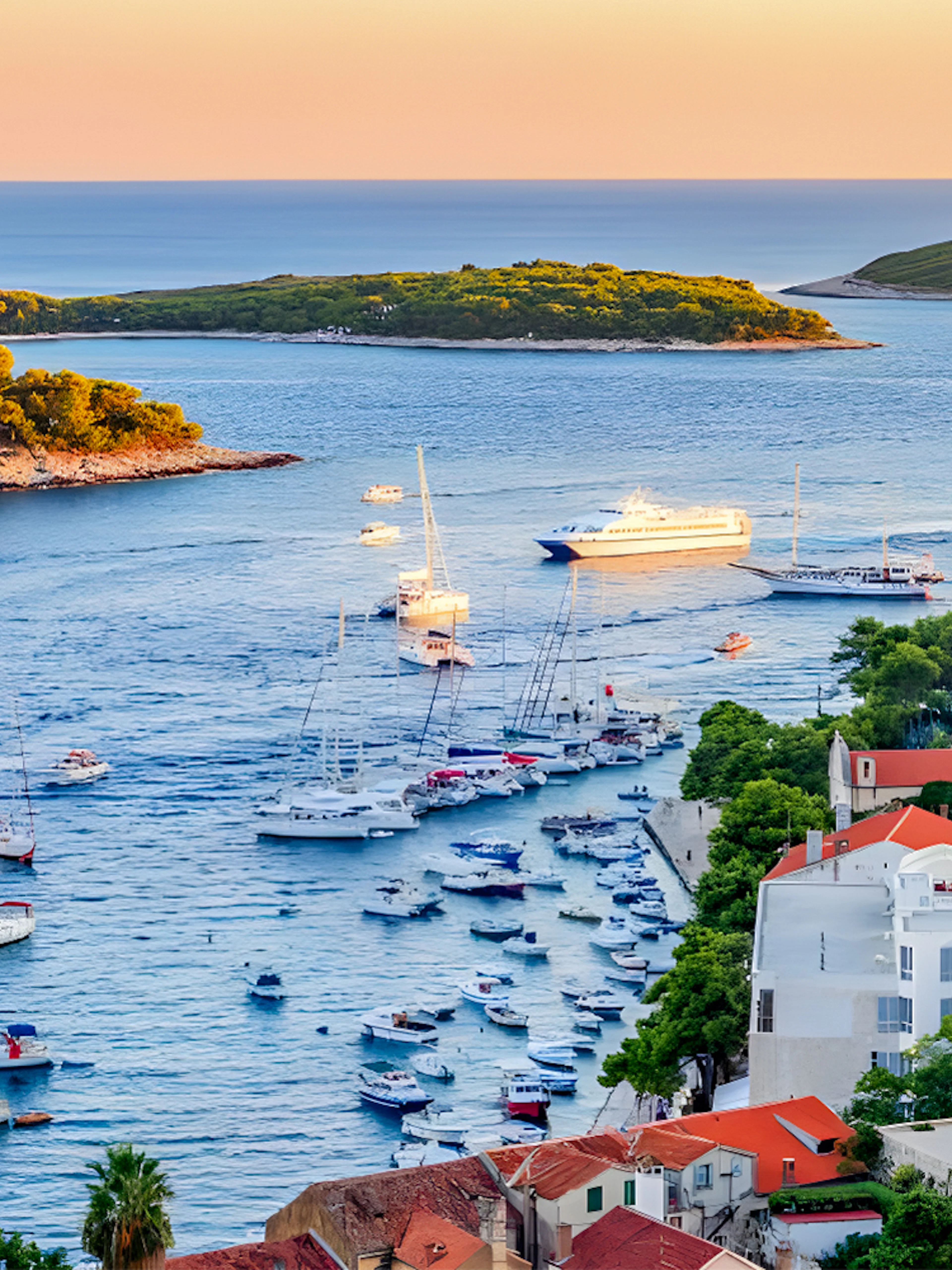 Boats sailing near Hvar Island with a view of the Adriatic Sea and coastal buildings.