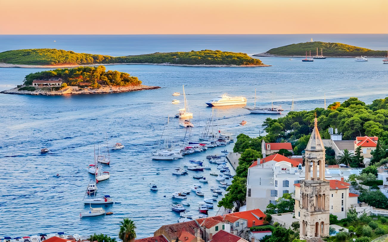 Boats sailing near Hvar Island with a view of the Adriatic Sea and coastal buildings.