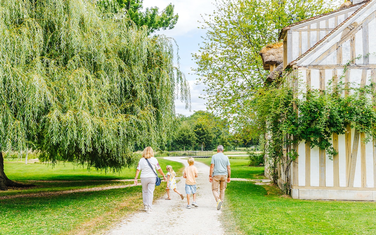 Family walking near a historic building at Chateau of Chantilly.