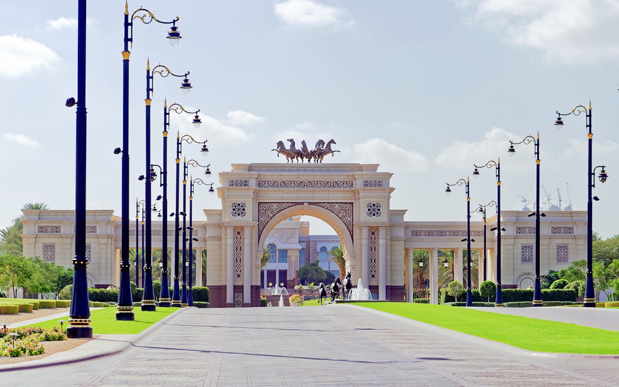 Grand entrance archway with horse statues on Dubai city tour.