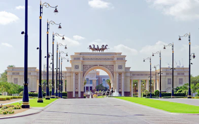 Grand entrance archway with horse statues on Dubai city tour.