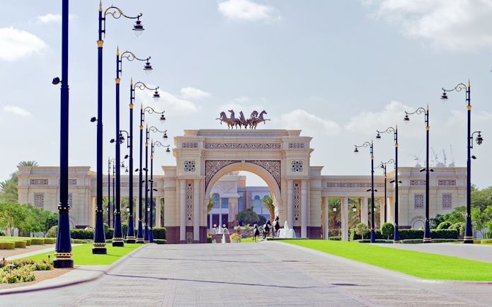 Grand entrance archway with horse statues on Dubai city tour.