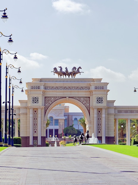 Grand entrance archway with horse statues on Dubai city tour.