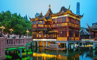 Yu Yuan Garden illuminated at night with traditional architecture in Shanghai, China.