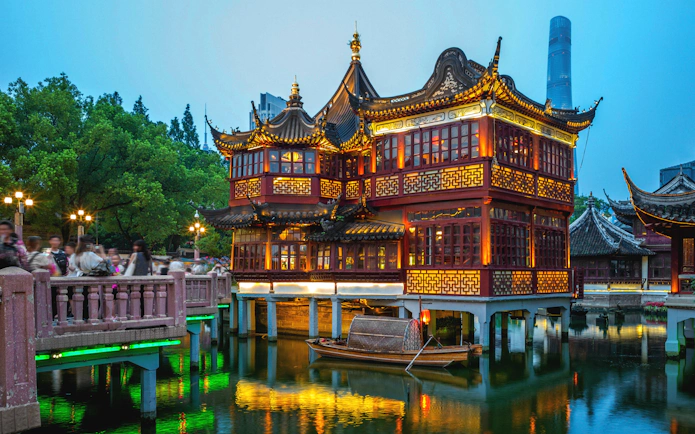 Yu Yuan Garden illuminated at night with traditional architecture in Shanghai, China.