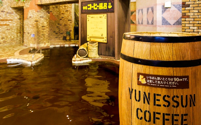 Hakone Kowakien Yunessun coffee-themed hot spring bath with wooden barrel labeled "Yunessun Coffee.