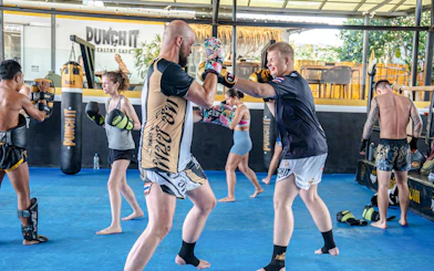 Beginners practicing Muay Thai boxing techniques in a Koh Samui training class.