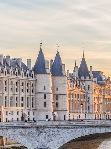 Conciergerie and Seine River at sunset in Paris.
