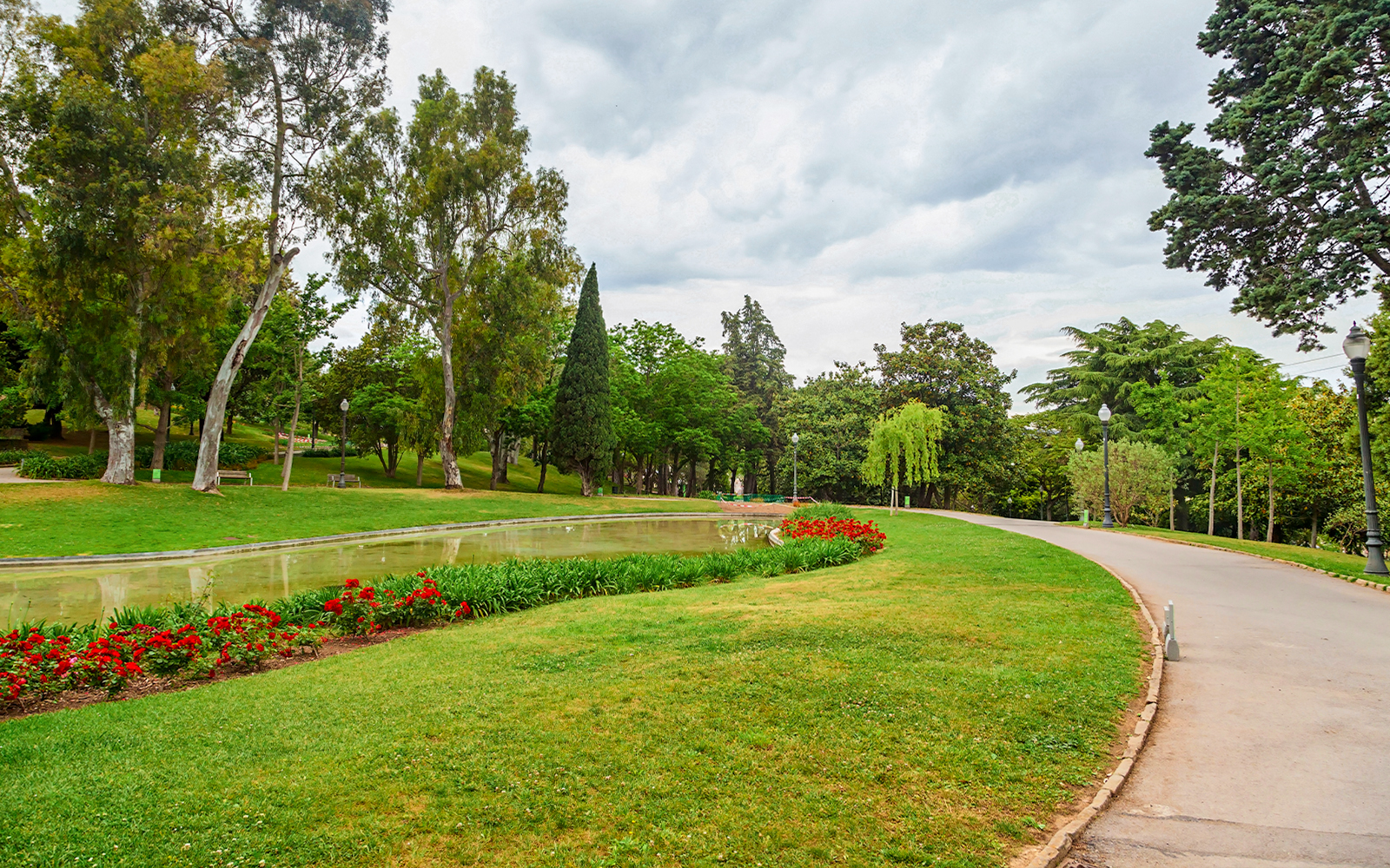 Montjuïc garden with pathway, trees, and flower beds in Barcelona.