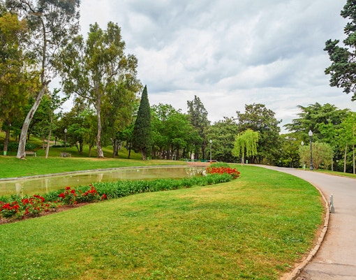 Montjuïc garden with pathway, trees, and flower beds in Barcelona.