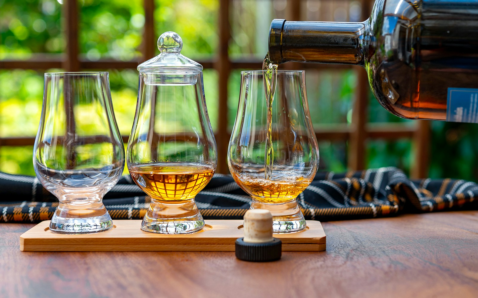 Whiskey being poured into a glass at a distillery tasting session.