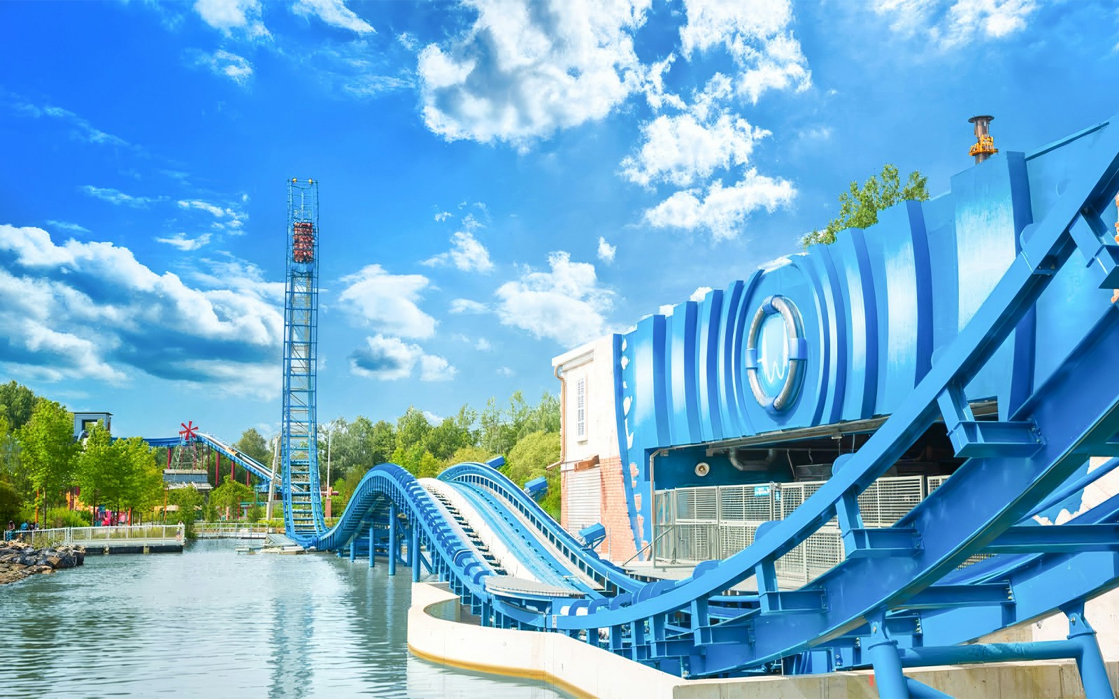 AQUAMAN™ Power Wave roller coaster at Six Flags Over Texas with water track and blue sky.