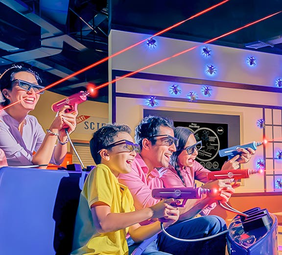 Family enjoying a laser tag ride at an indoor amusement park.