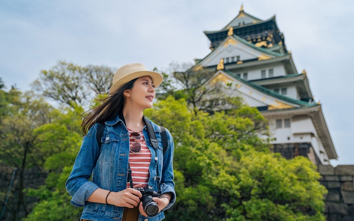 Traveler with camera near Osaka Castle, Japan.