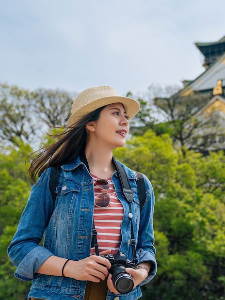 Traveler with camera near Osaka Castle, Japan.