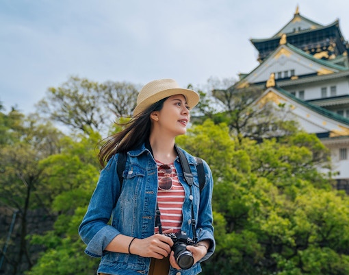 Traveler with camera near Osaka Castle, Japan.