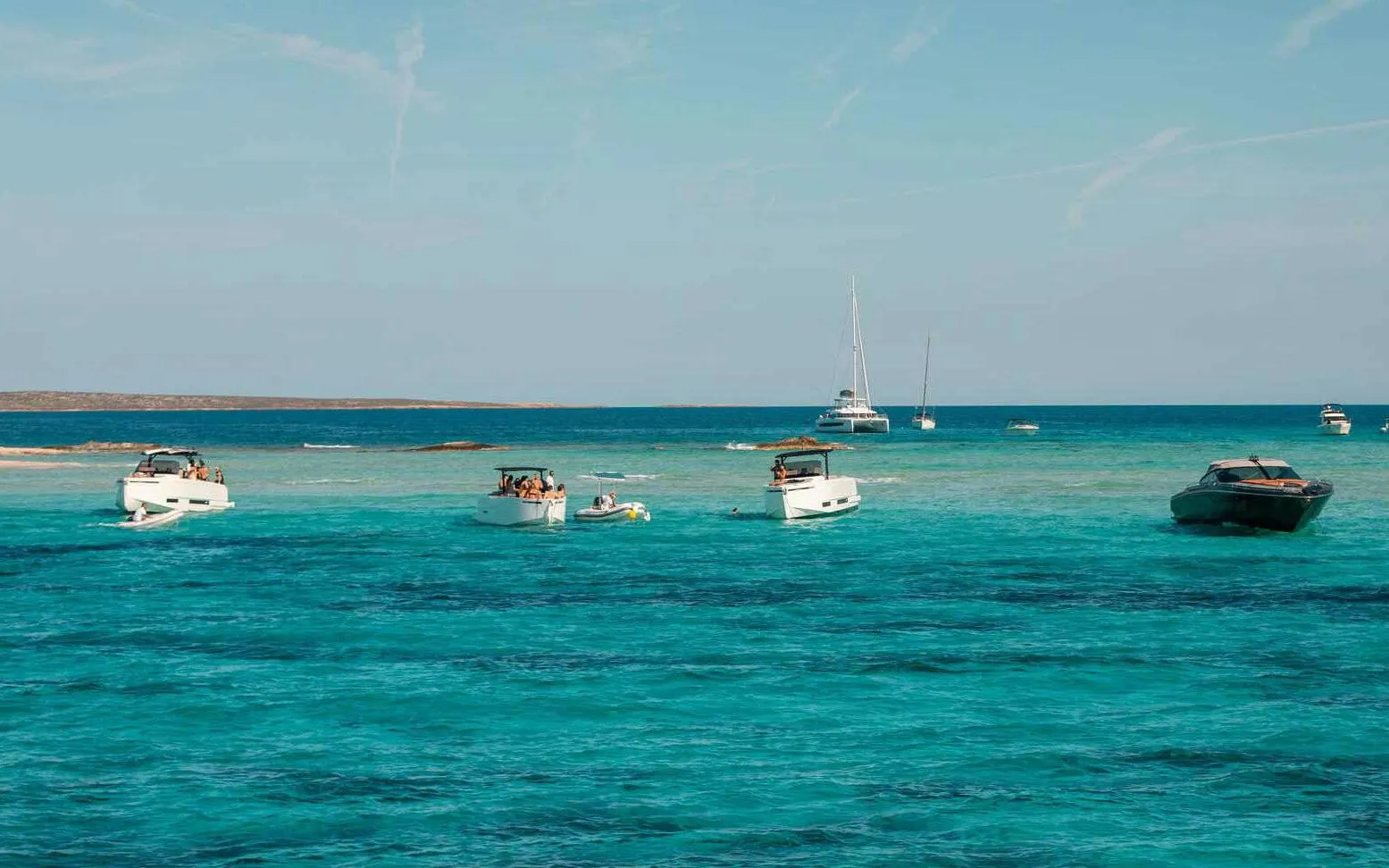 Boats cruising on turquoise waters between Ibiza and Formentera.