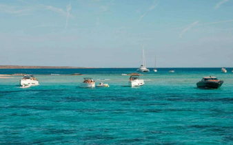 Boats cruising on turquoise waters between Ibiza and Formentera.
