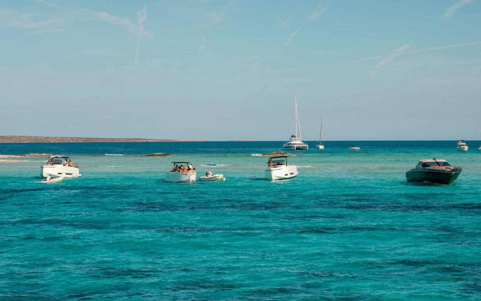 Boats cruising on turquoise waters between Ibiza and Formentera.