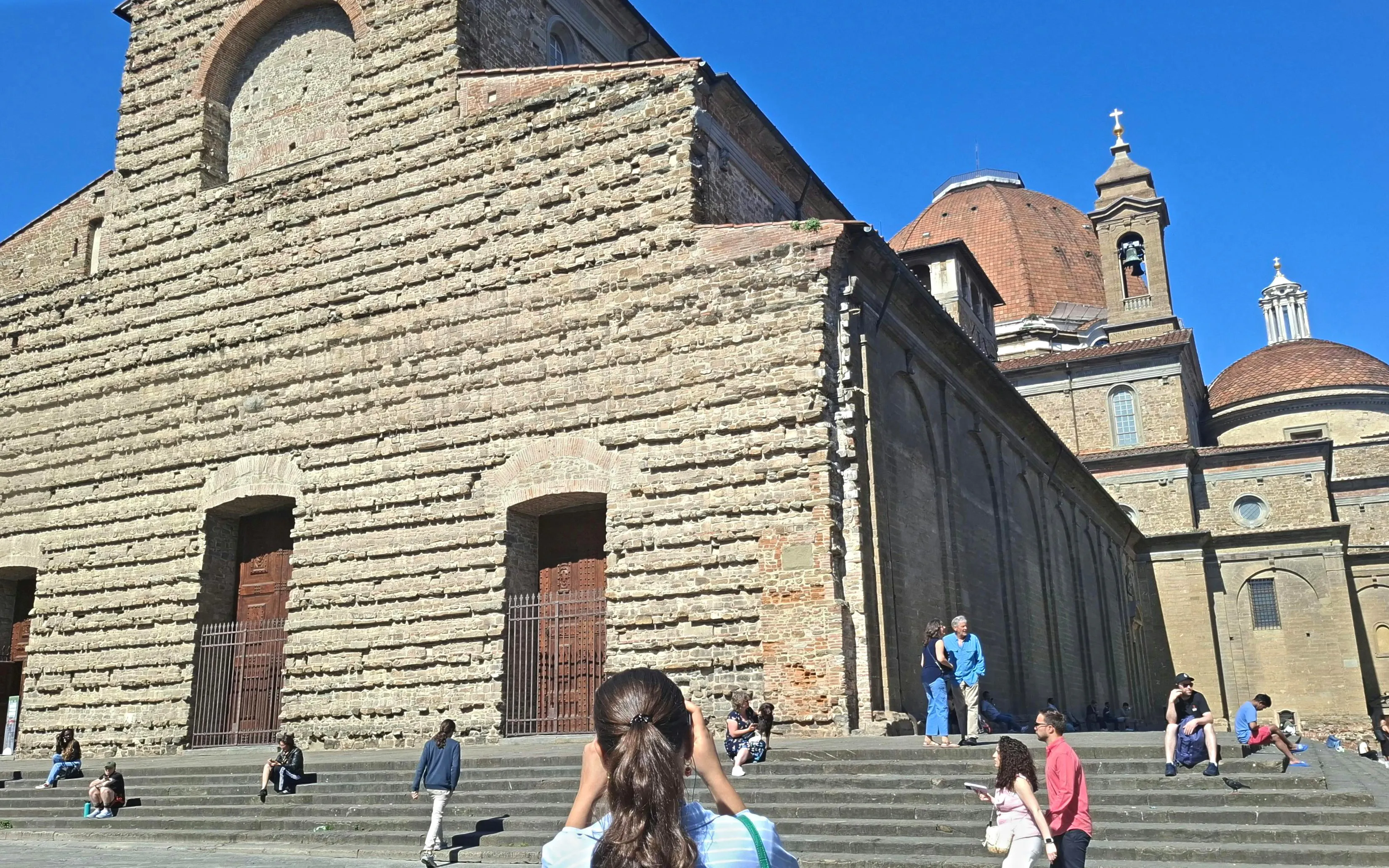 San Lorenzo Basilica exterior with tourists in Florence, Italy.