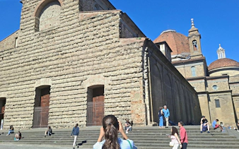 San Lorenzo Basilica exterior with tourists in Florence, Italy.