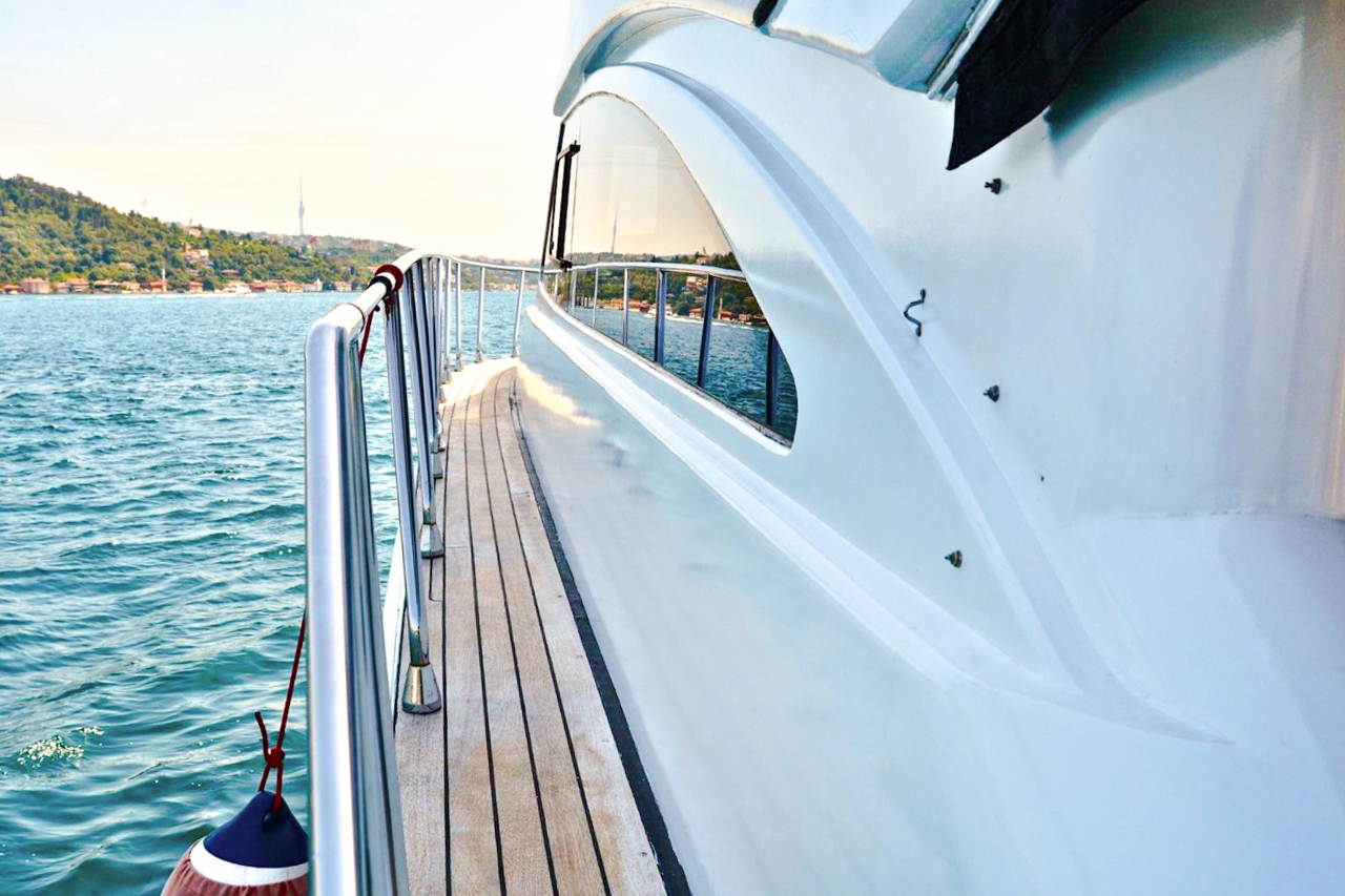 Luxury yacht deck with view of Istanbul coastline.
