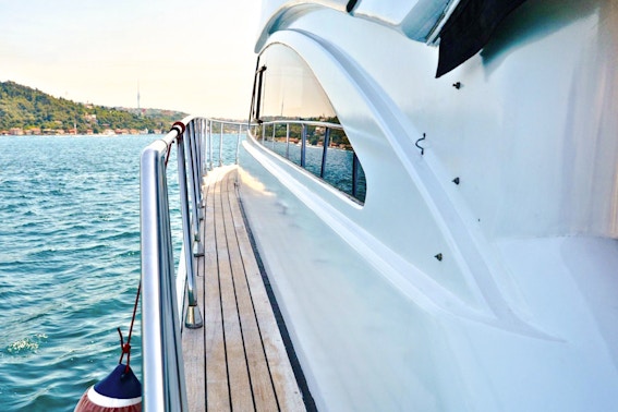 Luxury yacht deck with view of Istanbul coastline.