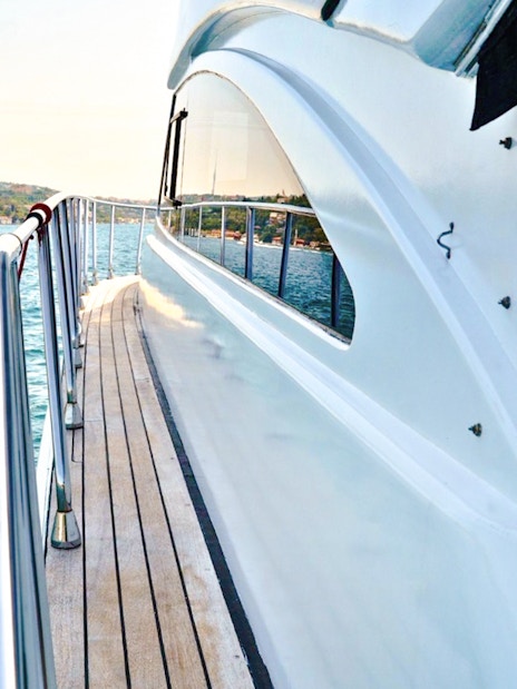 Luxury yacht deck with view of Istanbul coastline.