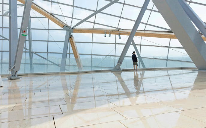 Visitor near glass window at Fondation Louis Vuitton, Paris.