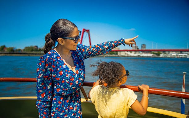 Guests enjoying the view from the Pancake Cruise in Rotterdam, with a bridge in the background.