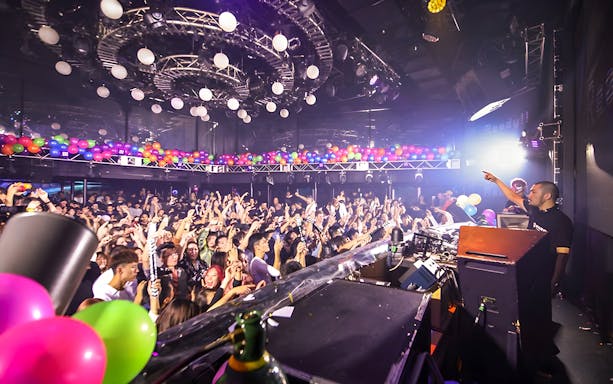Crowd enjoying a DJ performance at WARP Shinjuku Nightclub, Tokyo.