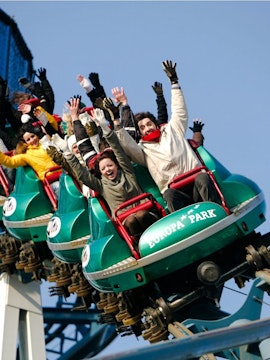 Guests on a roller coaster at Europa Park with hands raised in excitement.