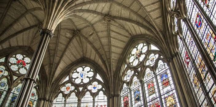 Stained glass windows and vaulted ceiling in Westminster Abbey's Chapter House, London.