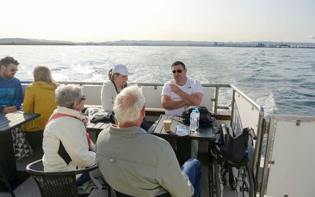 Guests enjoying a conversation on the Amelia Rose yacht during a whale watching cruise in Reykjavík.