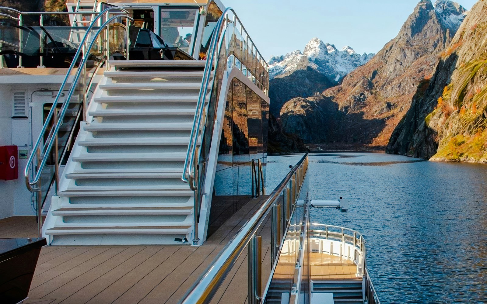 Cruise ship deck with stairs overlooking Trollfjord, Lofoten mountains in the background.