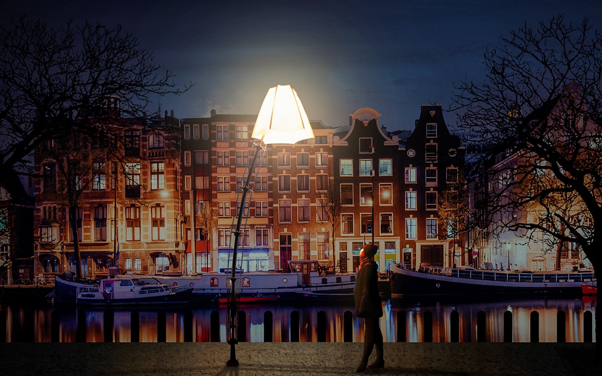 Amsterdam Light Festival installation with canal houses and boats at night.